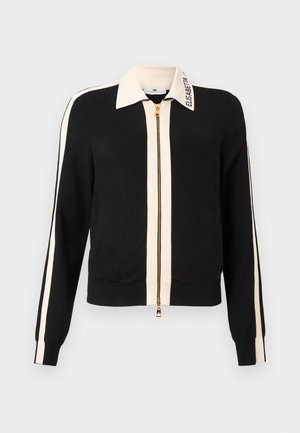 Mustast materjalist lukuga kampsun helebeežide triipude ja kaelusega. Omad ribitatud mansette, kuldset tõmblukku ning kaelusel logo. Sile kangapind.