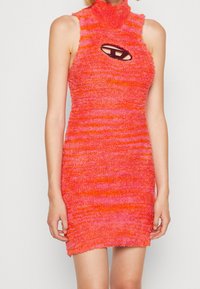 Robe mini en maille duveteuse dégradée orange et rose, avec un col montant et une découpe ovale au niveau de la poitrine. Design texturé et près du corps.