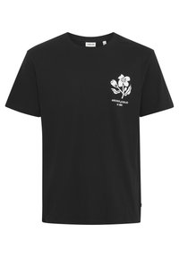 Sort bomulds t-shirt med rund hals. Har en hvid blomster grafik og teksten "ARCHIVE & SOLID 1999" på venstre brystområde.