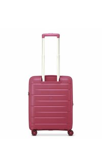 Valigia rigida di colore rosa intenso con scanalature orizzontali, manico bianco retrattile e quattro ruote nere per la mobilità.