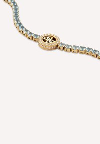 Bracciale in oro con gemme azzurre chiare e accenti trasparenti, dotato di un dettaglio centrale circolare e un design strutturato.