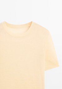 Helles beige T-Shirt mit rundem Ausschnitt und kurzen Ärmeln. Hergestellt aus einem weichen, glatten Stoff mit taillierter Form und minimaler Verarbeitung.