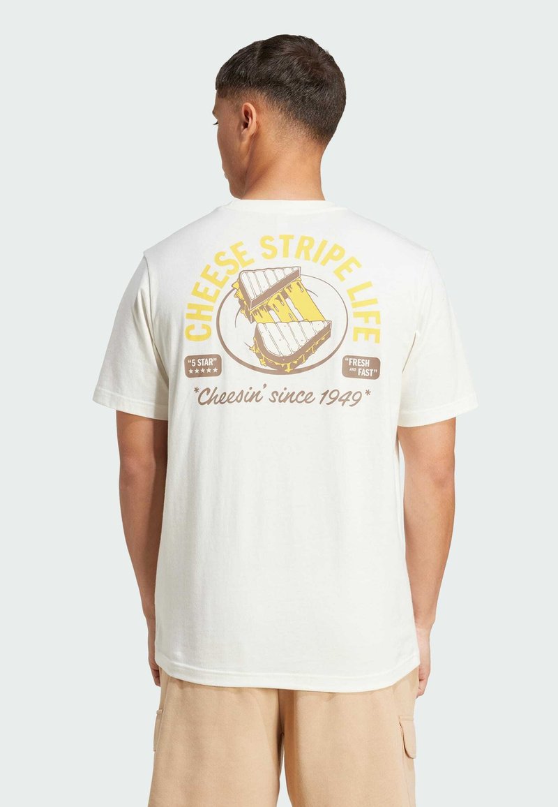 White cotton t-shirt featuring a graphic design on the back with text "CHEESE STRIPE LIFE" and an illustration of cheese. Short sleeves.