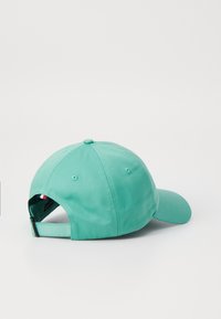 Menta zöld baseballsapka lekerekített koronával, hátsó állítható pánttal és szellőző lyukakkal; sima szövettextúra.