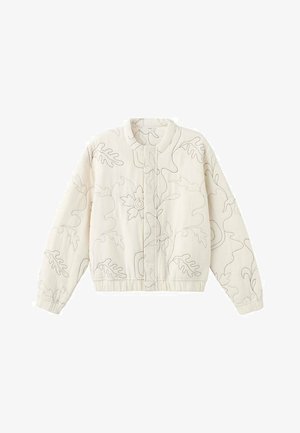 Cremefarvet bomberjakke med blomsterbroderi, kombineret med lyseblå bukser med vide ben. Modellen står foran en neutral grå baggrund.