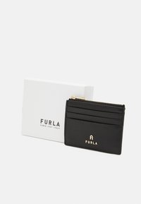 Black leather cardholder with multiple card slots and a zip compartment, featuring gold logo accents. Accompanied by white packaging.