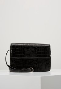 Borsa in pelle nera con effetto coccodrillo, dotata di chiusura a pattina, manico rimovibile e finitura liscia, caratterizzata da una forma rettangolare e linee pulite.