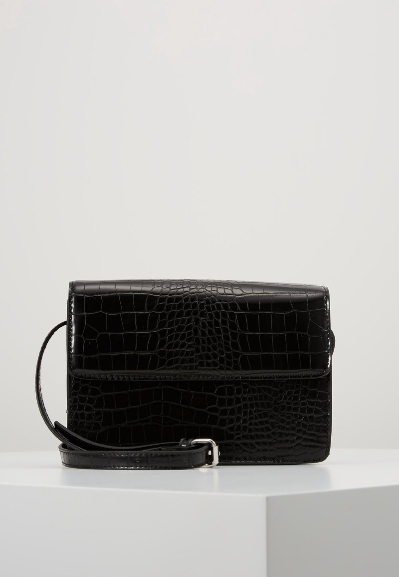 Borsa in pelle nera con effetto coccodrillo, dotata di chiusura a pattina, manico rimovibile e finitura liscia, caratterizzata da una forma rettangolare e linee pulite.
