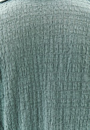 Texturiertem Stoff in gedämpfter Tealfarbe mit einem zerknitterten Oberflächenmuster. Weiches und leichtes Material, geeignet für Lagenlook oder lässige Kleidung.