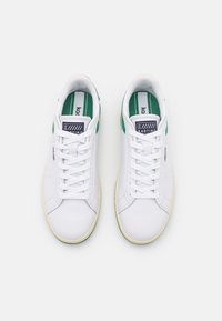 Sneakers bianchi con accenti verdi, dotati di design con lacci, materiale in pelle testurizzata e punta rotonda. Include foderatura interna con marchio.