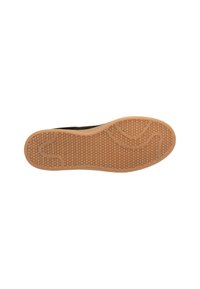 Schuhsohle mit Wabenmuster und glatten, geschwungenen Grifflinien aus tanfarbenem Gummi.