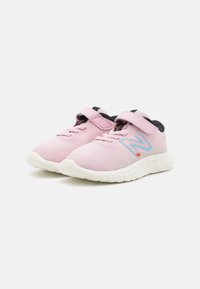 Baskets de sport en mesh rose avec des semelles en caoutchouc blanches, présentant une sangle velcro, un détail de lacets et un logo N bleu sur le côté.