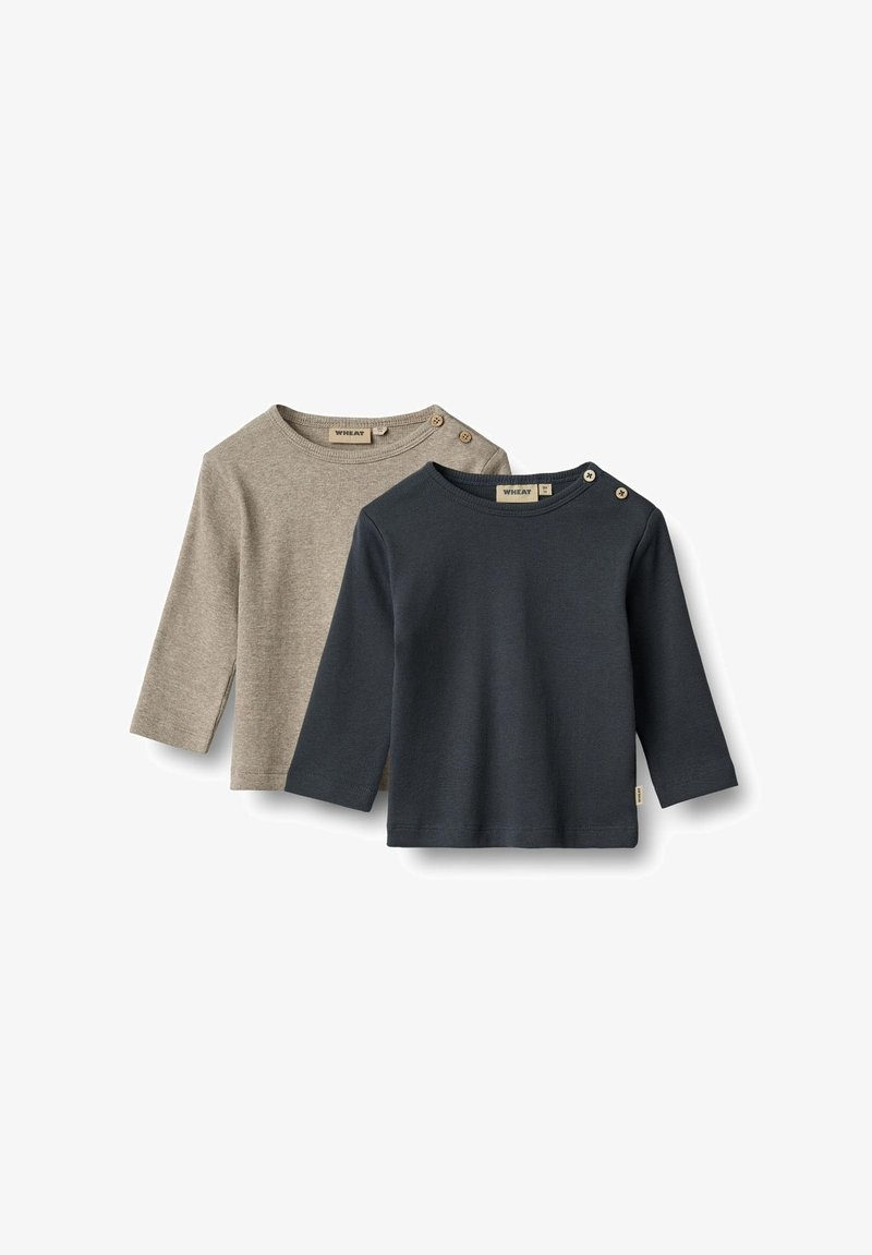 Deux chemises en coton à manches longues ; l'une beige avec des détails de boutons à l'épaule, l'autre bleu marine, toutes deux avec un col rond et une texture douce.