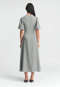 Graues Midikleid aus glattem Stoff, mit Puffärmeln, tailliertem Oberteil und einem geraden Rock, der unter das Knie fällt.