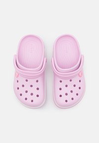 Różowe syntetyczne klapki z wieloma otworami wentylacyjnymi, okrągłym noskiem i białą podeszwą z logo po boku.