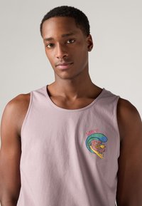 Svijetlopurpurasti pamučni top bez rukava s šarenim grafičkim dizajnom i natpisom "LEVI'S", okrugli izrez i široke otvore za ruke za udobnost.