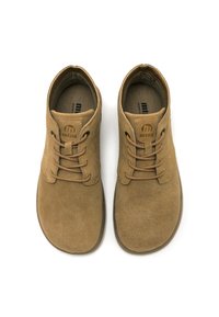 Scarpe scamosciate color beige con punta arrotondata, dotate di un sistema di allacciatura e di un logo discreto sulla linguetta. Suola piatta per il massimo comfort.