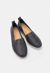 Námořnické kožené slip-on boty s hladkým povrchem, polstrovanou stélkou a texturovanou gumovou podrážkou, zdobené jemnými švy.