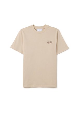 Camiseta de algodón color beige con mangas cortas, cuello redondo y un pequeño gráfico marrón que dice "SUNDAY Brunch" en el área del pecho izquierdo. Textura suave.