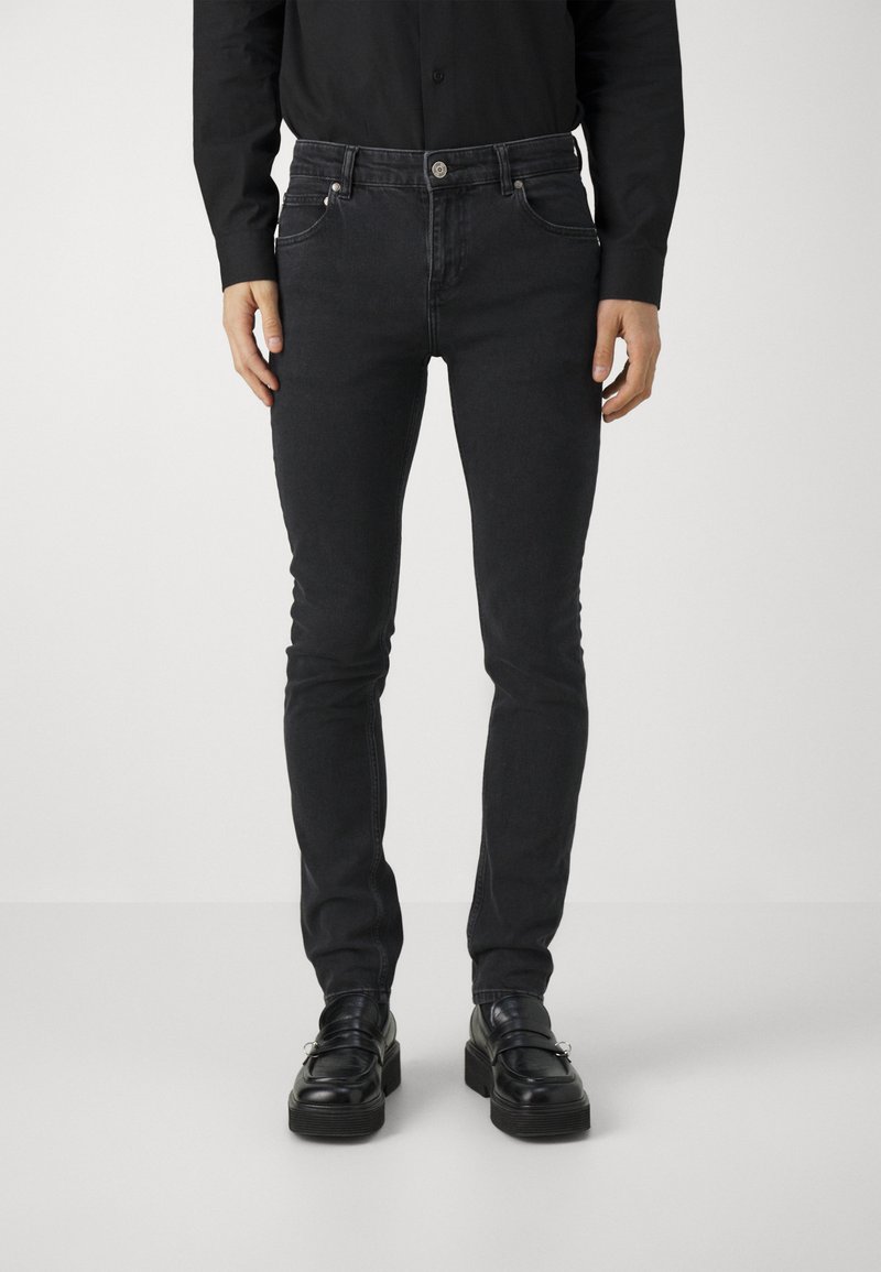 Black slim-fit jeans made of denim, featuring classic five-pocket design, subtle stitched detailing, and a smooth texture.