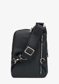 Černá kožená crossbody taška s texturovaným povrchem, nastavitelným popruhem, zipovými kapsami a kovovými akcenty.