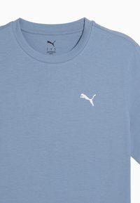 Lys blå kortærmet skjorte lavet af blødt materiale. Har et hvidt broderet Puma-logo på venstre brystområde.