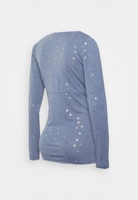 Camisola de manga longa azul feita de um tecido macio, com um padrão metálico disperso. A vista traseira mostra um decote redondo e uma silhueta ajustada.