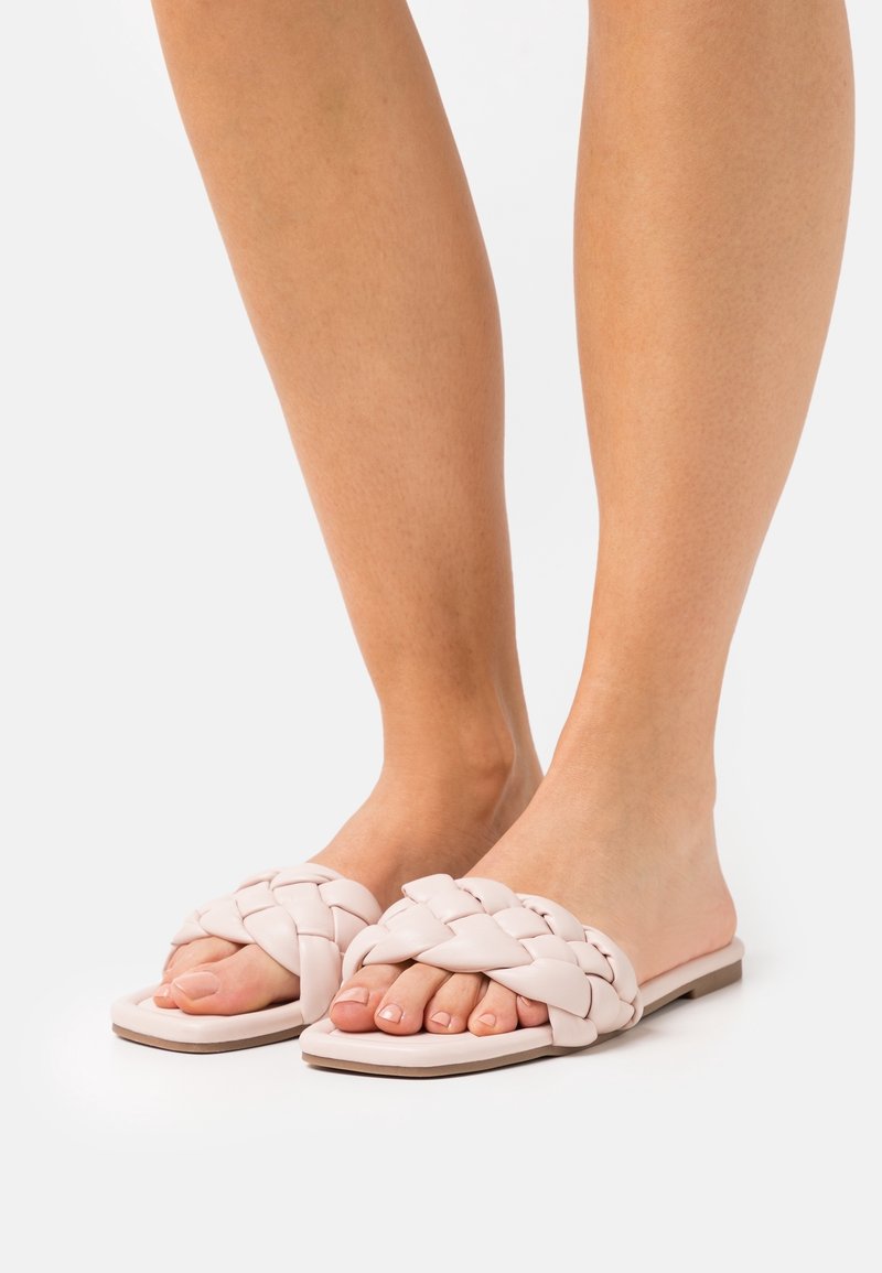 Ljust rosa, vävda lädersandaler med platt, öppen tådesign och en strukturerad yta. Har en minimalistisk profil och rektangulär sula.