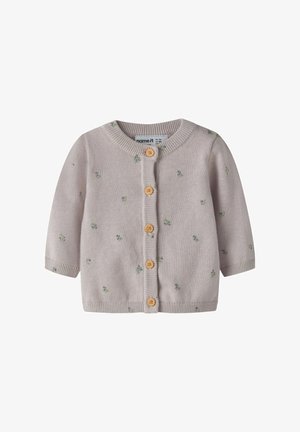 Vaaleanpunainen vauvan neuletakki, jossa on pieniä vihreitä ja sinisiä kukkakuvioita sekä viisi puista nappia edessä.