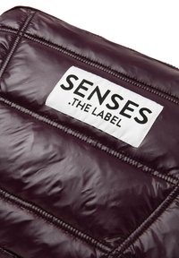 Burgunderfarbene Daunenjacke mit einem weißen Etikett "SENSES .THE LABEL." Texturierte Oberfläche mit genähten Paneelen und glänzender Optik.