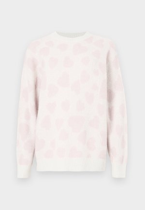 Hvid sweater med en blød tekstur, der har et lyserødt hjerte mønster. Rund hals og ribstrikkede ærmegab fremhæver designet.