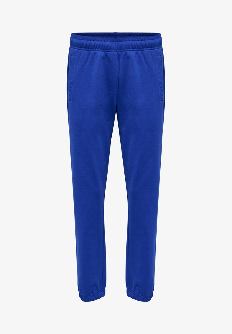 Niebieskie dresy z elastycznym paskiem, dwiema bocznymi kieszeniami i elastycznymi mankietami przy kostkach. Gładka tekstura materiału. Luźny krój.