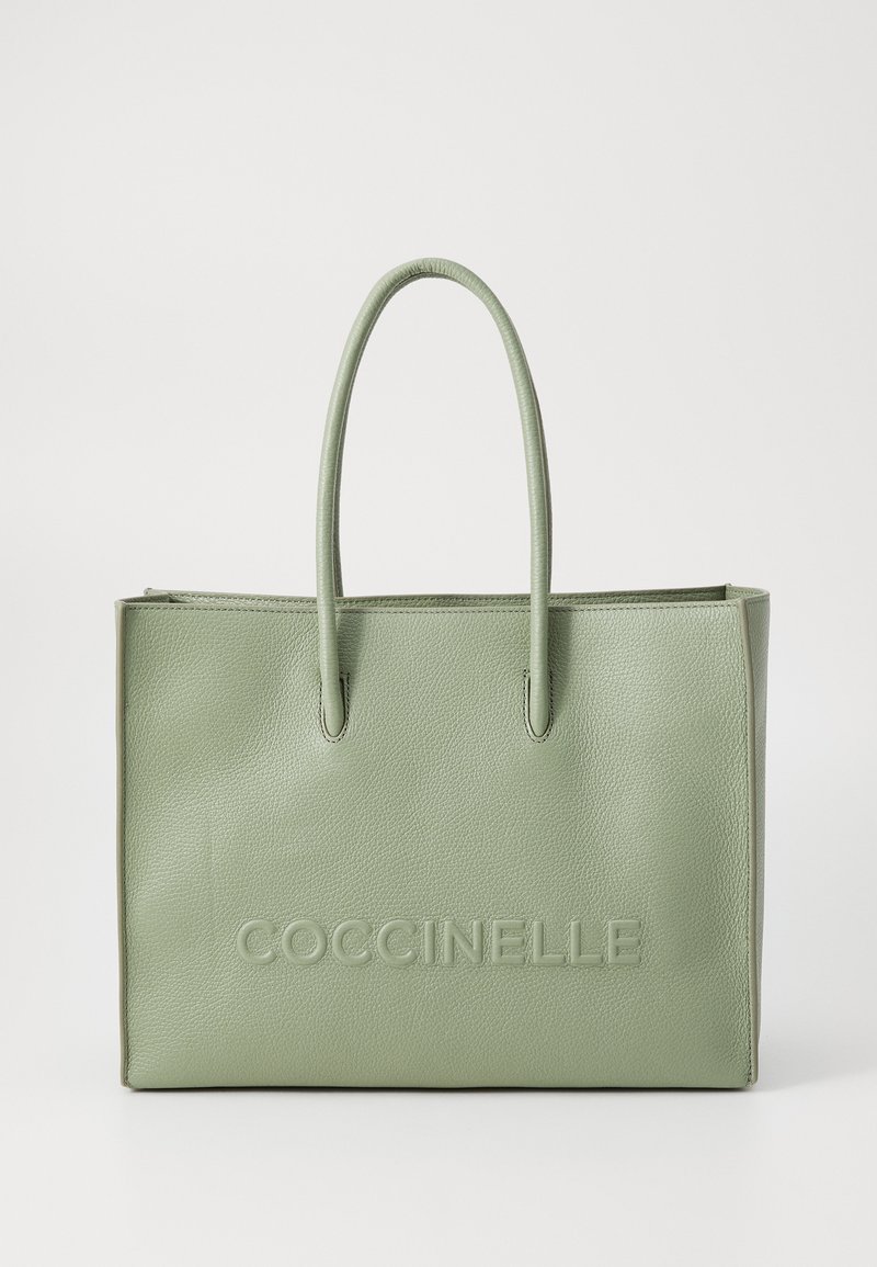 Green leather tote bag with a textured finish, featuring two sturdy handles and embossed "COCCINELLE" logo on the front.