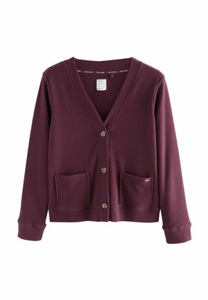 Burgundský žebrovaný cardigan s výstřihem do V, pěti knoflíky, dvěma předními kapsami a žebrovanými manžetami. Vyrobeno z měkké látky s uvolněným střihem.