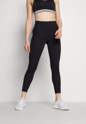Leggings neri a vita alta con una texture liscia, dotati di una tasca laterale con zip, abbinati a un reggiseno sportivo nero coordinato.