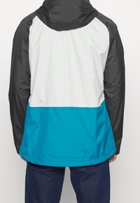 Color-blocked jacket featuring a black hood, white upper section, and turquoise lower section, made from lightweight, water-resistant material.