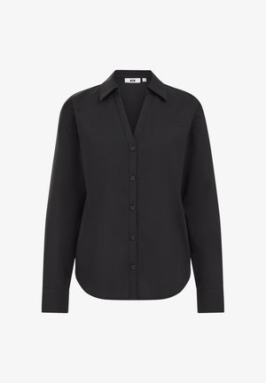 Črna dolga majica z dolgimi rokavi in ovratnikom, z gumbom spredaj in gladkim, lahkim materialom. Prilagojena, sproščena kroj.