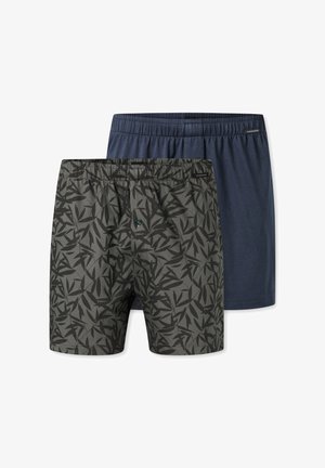 Två par herrboxers: ett par i ensfärgad marinblå och det andra grått med ett mönster av svarta löv. Båda har elastiska midjeband och en avslappnad passform.