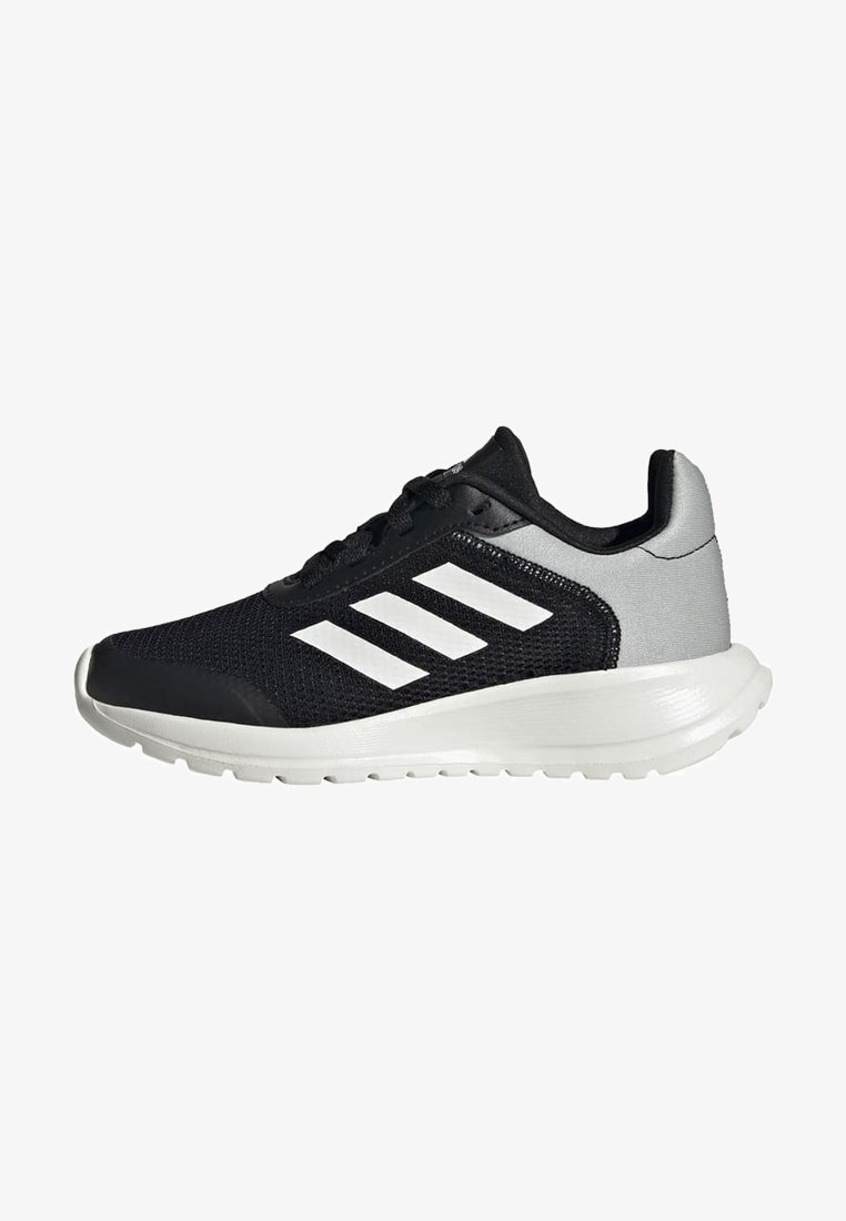 Scarpa sportiva nera con tomaia in maglia, tre strisce bianche di lato e contrafforte grigio. Presenta una suola bianca e testurizzata.