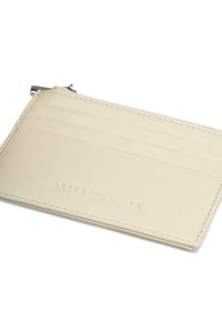 Crème leren kaarthouder met vier sleuven. Kenmerkend zijn de subtiele reliëfbranding en de fijne stiksels langs de randen. Compact en minimalistisch ontwerp.