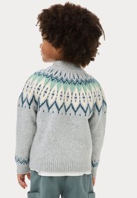 Maglione grigio lavorato a maglia con un giromanica decorato in turchese, bianco e blu navy; polsini e orlo a coste; mostrato dal retro su un bambino.