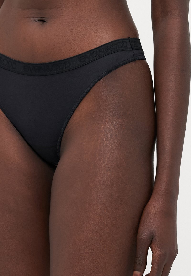 String noir en coton avec une ceinture fine affichant le nom de la marque "EVEN&ODD", présentant une texture lisse et un design minimaliste.