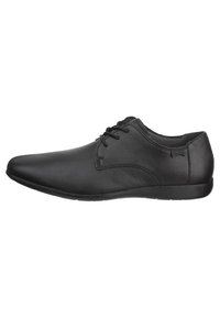 Chaussures de ville en cuir noir avec une texture lisse, bout arrondi et système de laçage. Présentent une silhouette épurée et minimale avec une semelle plate.