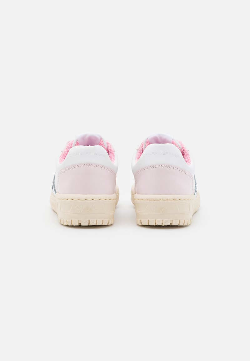 Weiße Sneaker mit rosa Akzenten, ausgestattet mit einem strukturierten Rücken und glatten Lederseiten, montiert auf einer beigen Gummisohle mit einem Profilmuster.