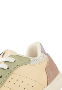 Schuh aus einer Mischung aus cremefarbenem, grünem und lavendelfarbenem Leder mit Wildlederakzenten, strukturierten Seiten, perforierten Details und weißen Schnürsenkeln.