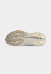 Semelle de chaussure avec bande de roulement en caoutchouc beige et blanc cassé, comportant des rainures et des motifs de grip texturés pour la traction et la flexibilité.