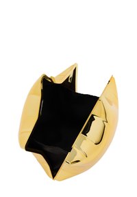 Arannyal bevont, fém clutch táska elegáns, szoborszerű formával és nyitott tetejével. A belseje kontrasztos fekete bélést tartalmaz.