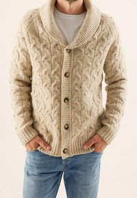 Beige Kabelstrick-Cardigan mit Schalkragen, gerippten Bündchen und fünf großen Knöpfen. Hergestellt aus strukturiertem Garn mit gesprenkelten Details.