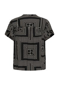Blouse noire à manches courtes avec des motifs géométriques beiges en carrés et cercles, coupe ample et léger pli dans le dos.