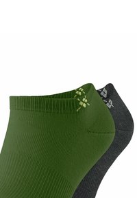 Chaussettes de cheville vertes et noires présentées côte à côte, avec un tissu texturé et des motifs simples agrémentés de détails de couture contrastés.